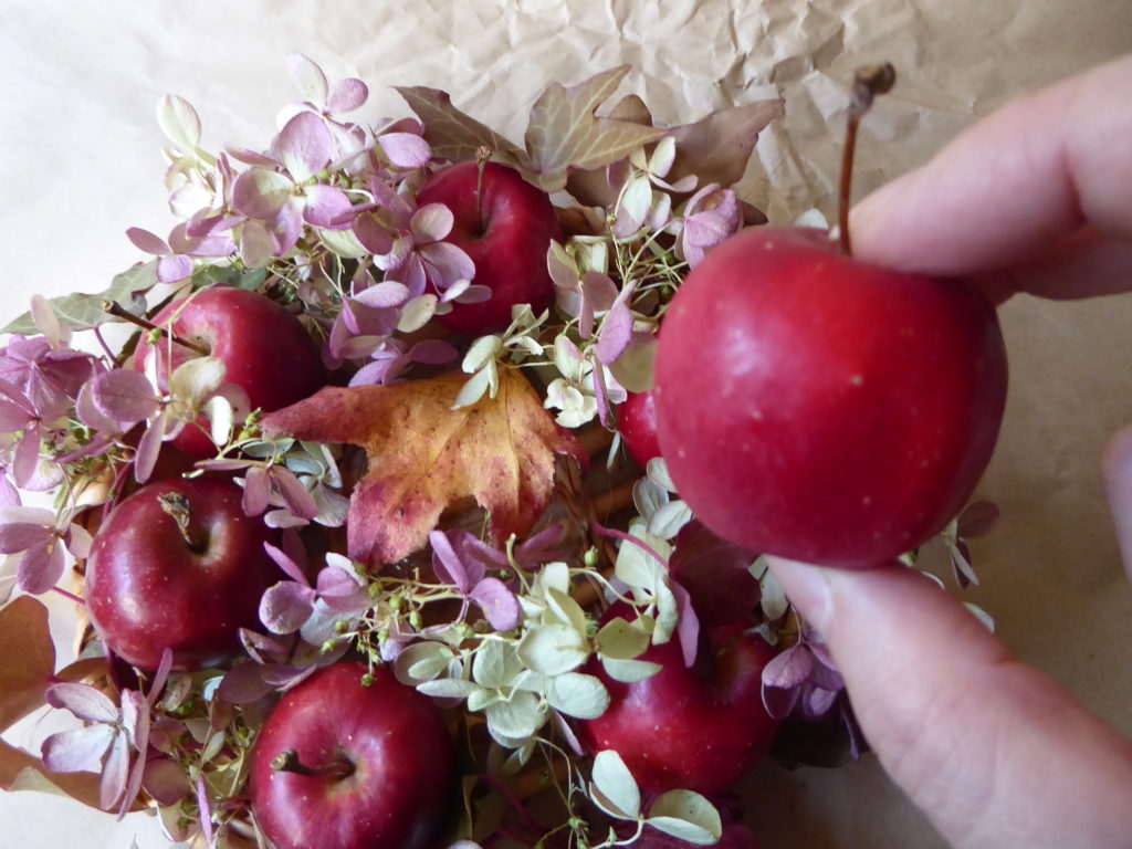 紅葉ミナヅキの真ん中の器に落ち葉をのせ、最後の姫リンゴをのせる写真