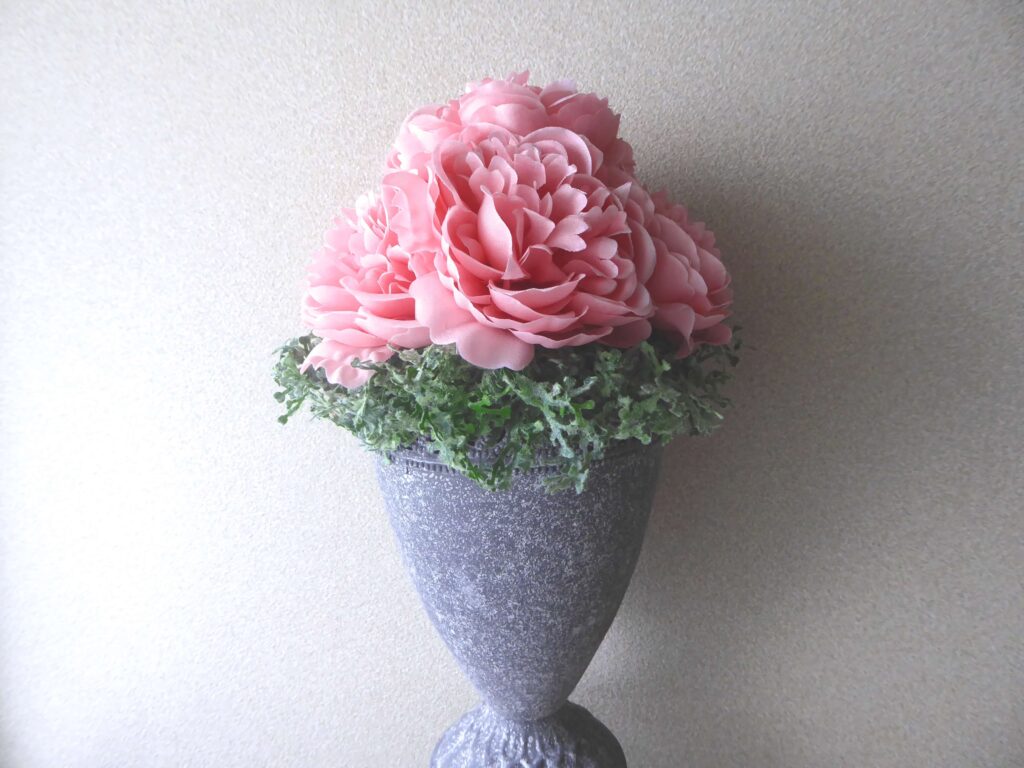 グリーンガーランドの花びんに束ねたアーティフィシャルのバラを生けた写真