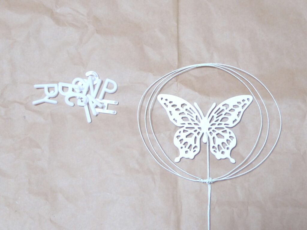 アルファベットパーツ（左）と輪のピックに白い蝶のピックを合わせた（右）写真