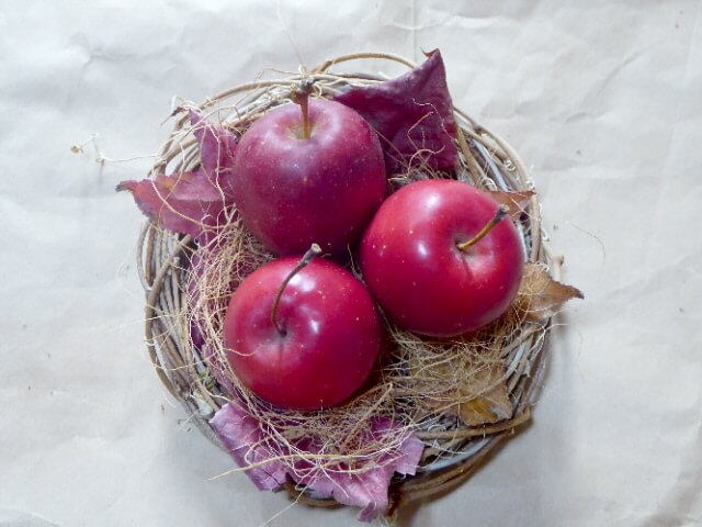 ヤシファイバーの上に姫リンゴ3つを置いた写真